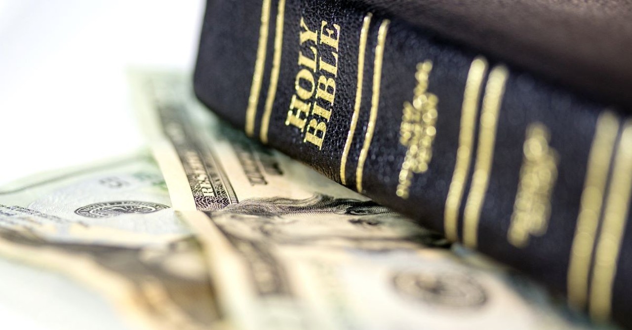 A Bible on top of a pile of cash