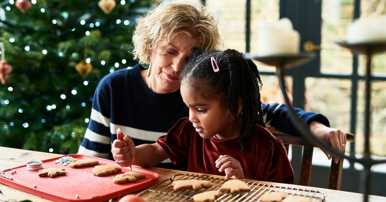 Grandma and granddaughter baking and decorating Christmas cookies christmas tree
