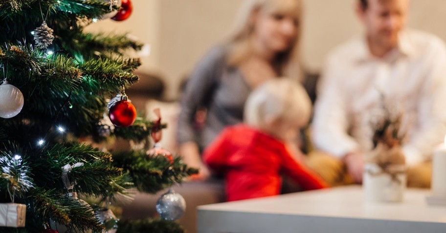 family in blurred background with christmas tree; prayer for christmas