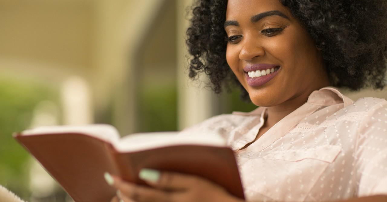 woman smiling reading her Bible